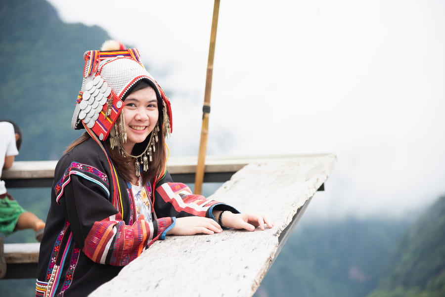 Mujer China con sombrero típico sonriendo a la cámara. Está en Yunnan